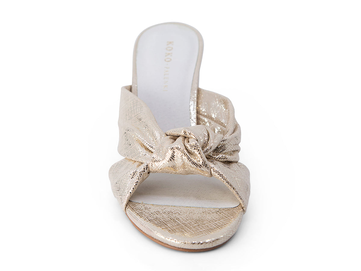 Gold metallic sandal with a bow on a white background front view